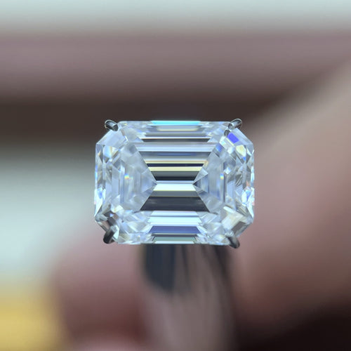 Emerald moissanite loose stone held face-up in a prong holder, D colour VVS clarity — Caratura