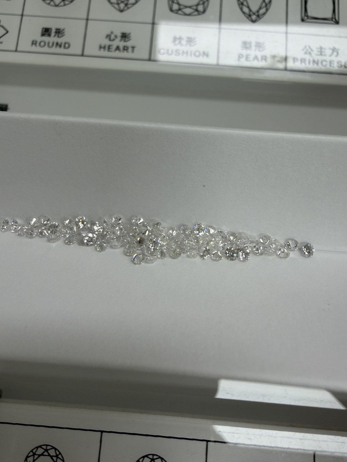 Round lab-grown diamond melee, DE VS-VVS, on an inspection tray