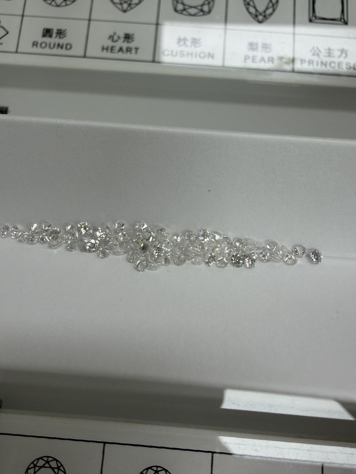 Round lab-grown diamonds, DE VS-VVS, on an inspection tray