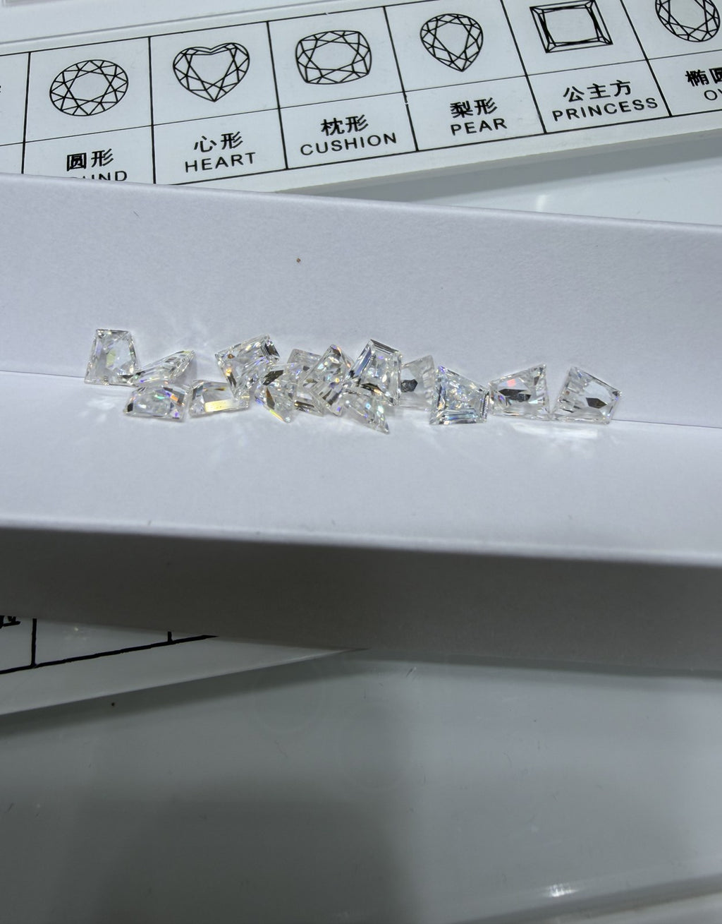 Trapezoid lab-grown diamond melee, DE VS-VVS, on an inspection tray