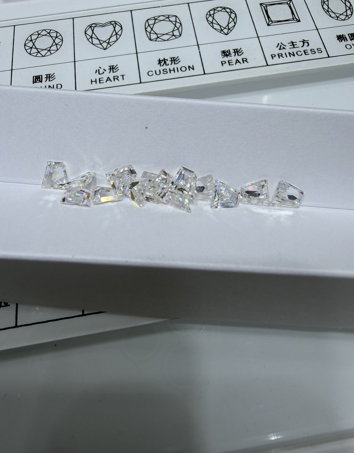 Trapezoid lab-grown diamond melee, DE VS-VVS, on an inspection tray