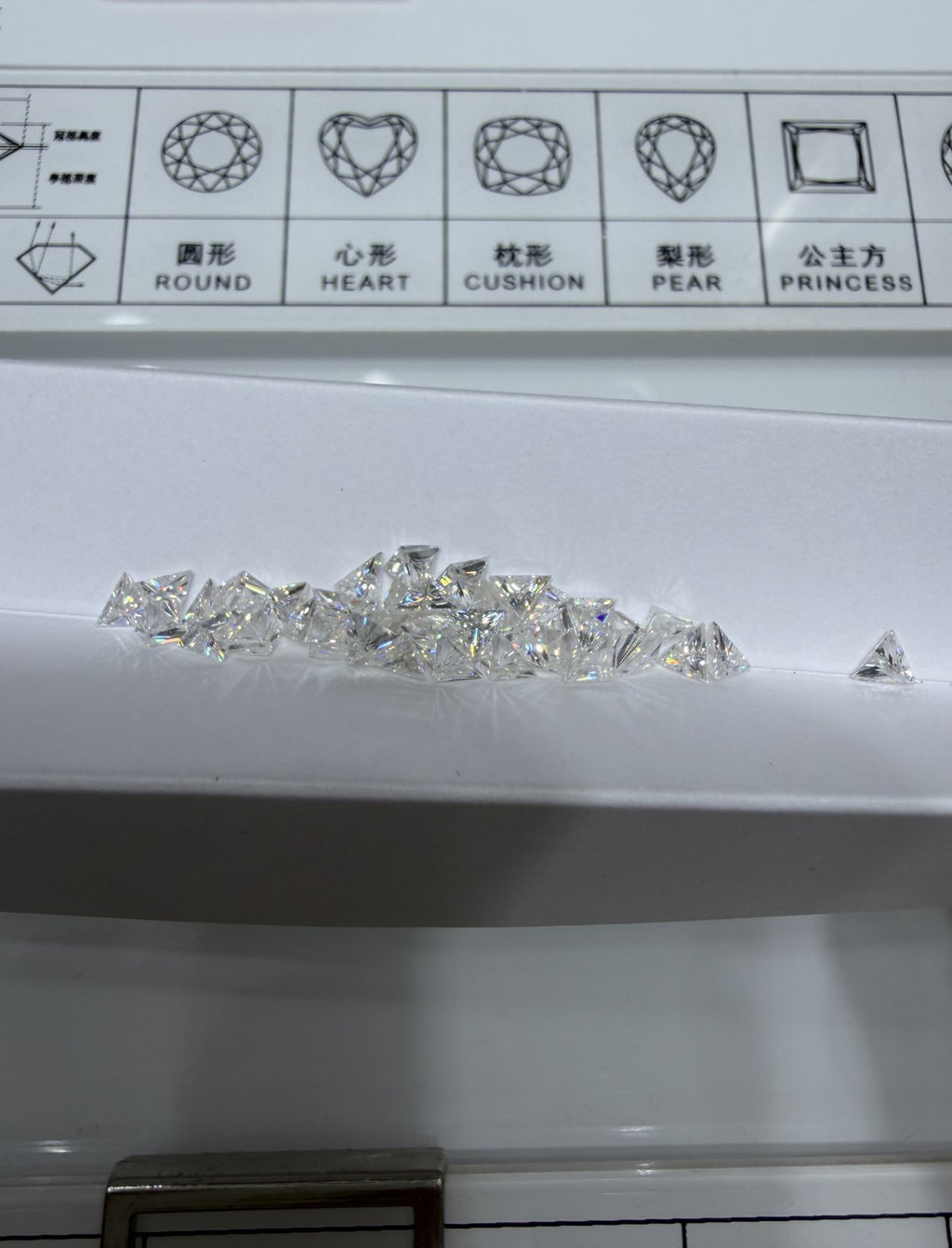 Triangle lab-grown diamond side stones, DE VS-VVS, on an inspection tray